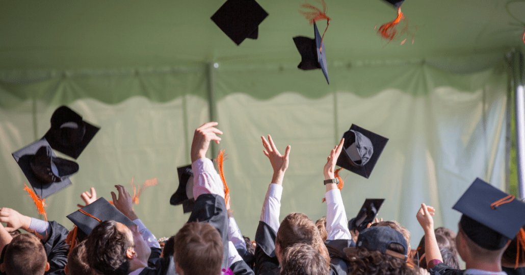 Students toss their caps into the air as a symbol of graduation.