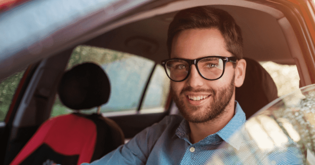 Muž sedí v autě a řídí, protože má řidičský průkaz.